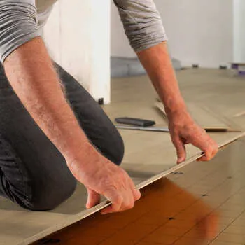 Instalador posicionando piso laminado