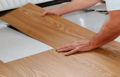 Instalador encaixando régua de piso vinílico